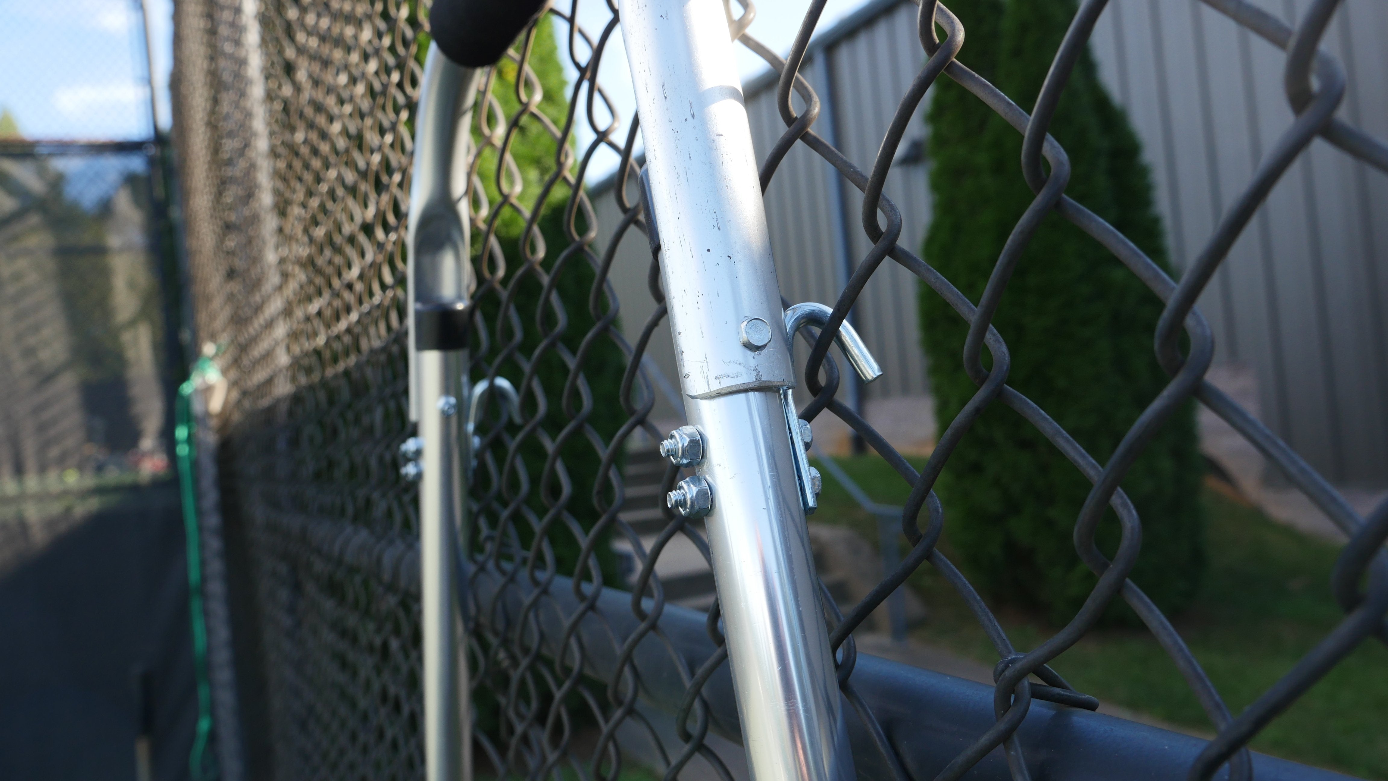 Tennis court drag broom hanging from fence